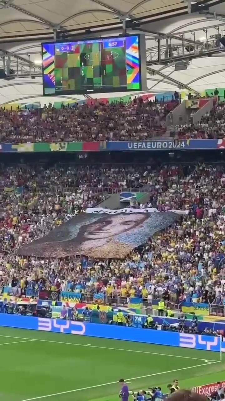 乌克兰vs比利时，乌克兰球迷高举载有182张乌克兰士兵照片的横幅，写着“和平